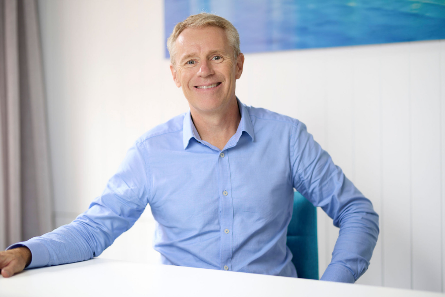 Business professional in an office appearing deep in thought, with paperwork and files on the desk, symbolising financial stress and insolvency challenges.
